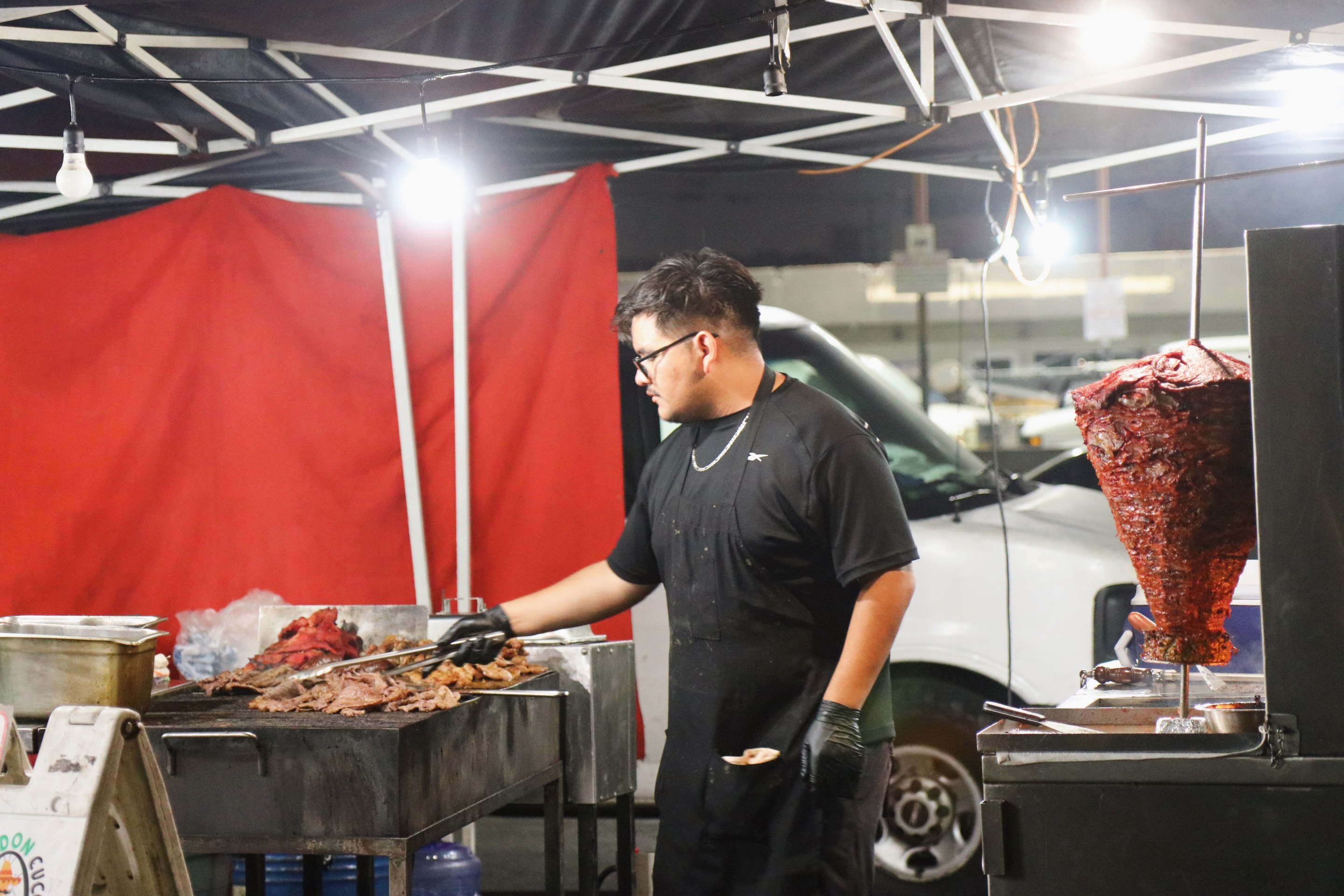 young taquero attends to the grill